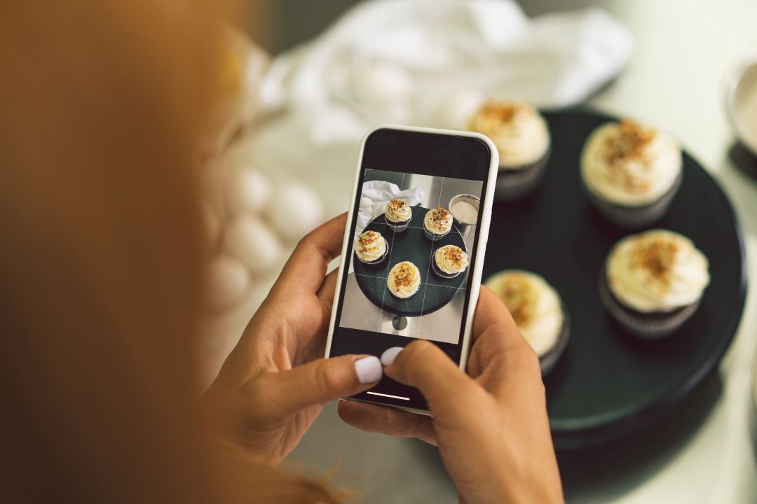 konditormadchen-das-cupcake-fur-ihr-blog-madchen-fotografiert-macht-ein-foto-von-cupcakes-auf-einem-smartphone